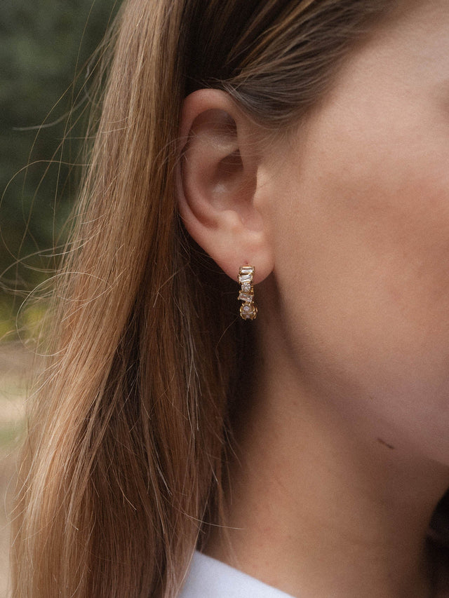 Elegante, roségoldene Ohrringe mit funkelndem Detail, getragen von PURELEI.