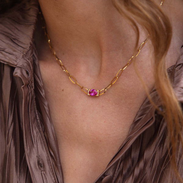 Goldene Kette mit einzigartigem Anhänger, getragen auf einer eleganten Bluse von PURELEI.