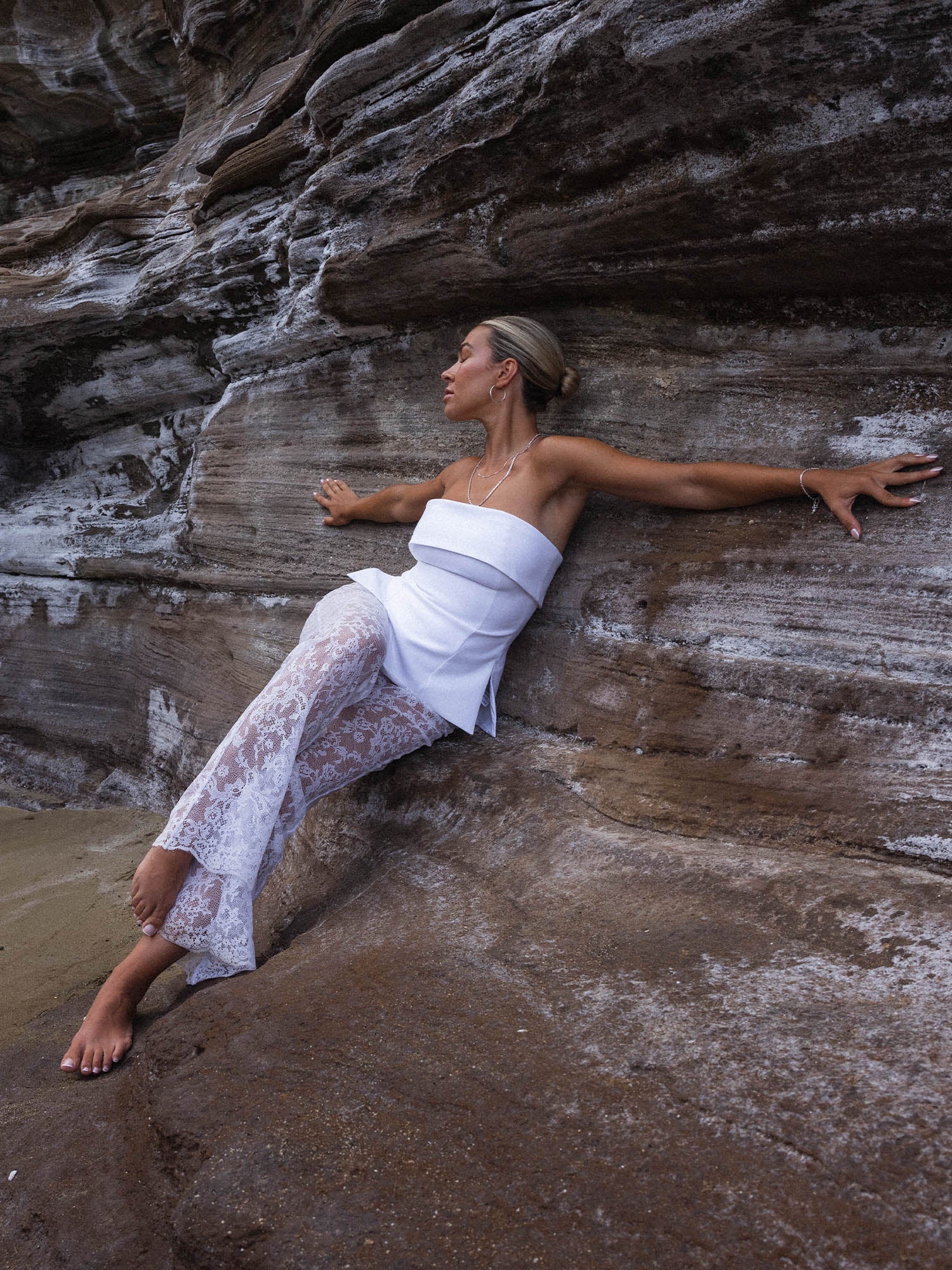 Feminine PURELEI Gleam Kette aus Silber mit schimmernder Süßwasserperle, getragen vor Felskulisse – strahlend und elegant.