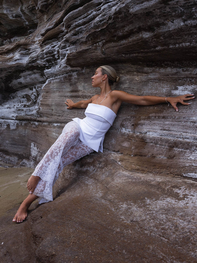 Feminine PURELEI Gleam Kette aus Silber mit schimmernder Süßwasserperle, getragen vor Felskulisse – strahlend und elegant.