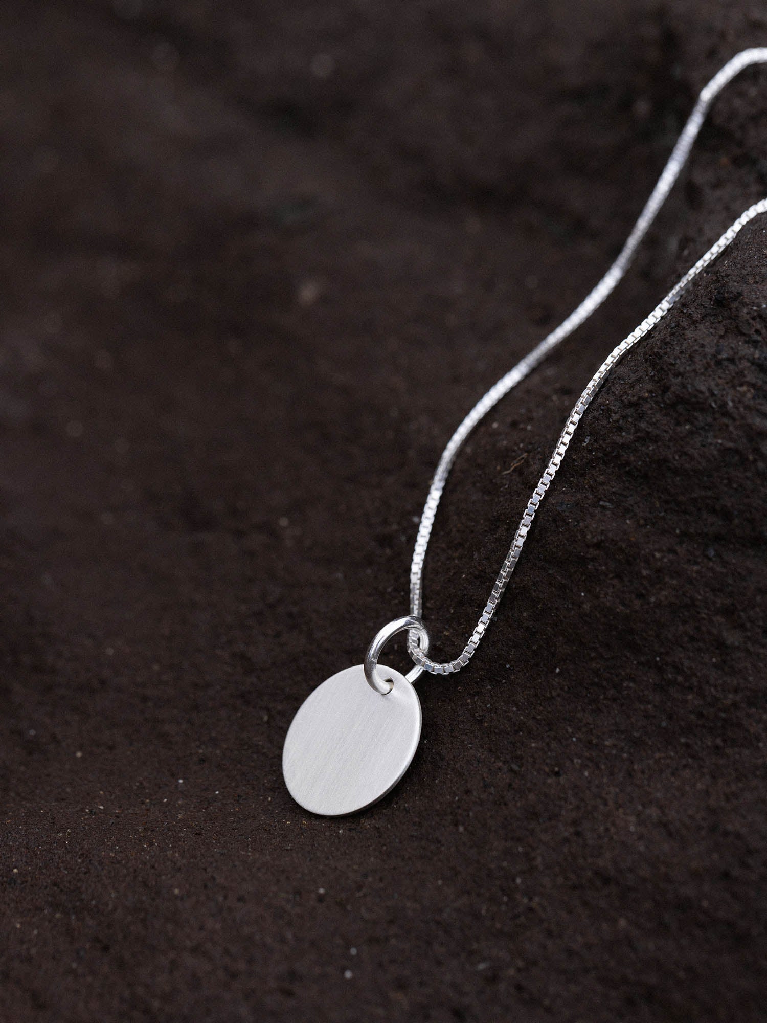 Perfection Charm von PURELEI: runder, nickelfreier Silberanhänger an filigraner Kette, puristisch und elegant inszeniert.