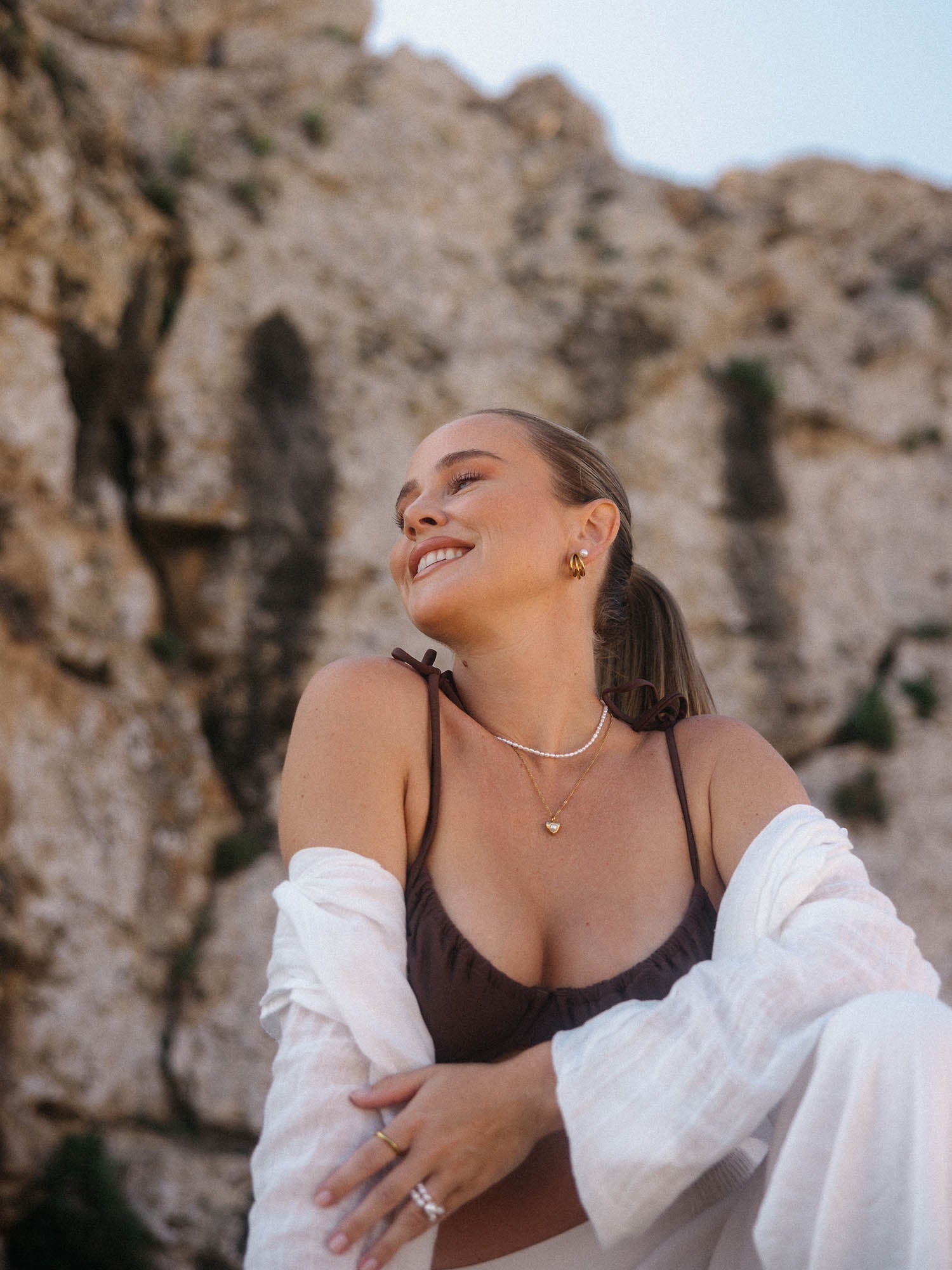 Elegante PURELEI Schmuckstücke, getragen vor einer Felsenkulisse, strahlen natürliche Schönheit aus.