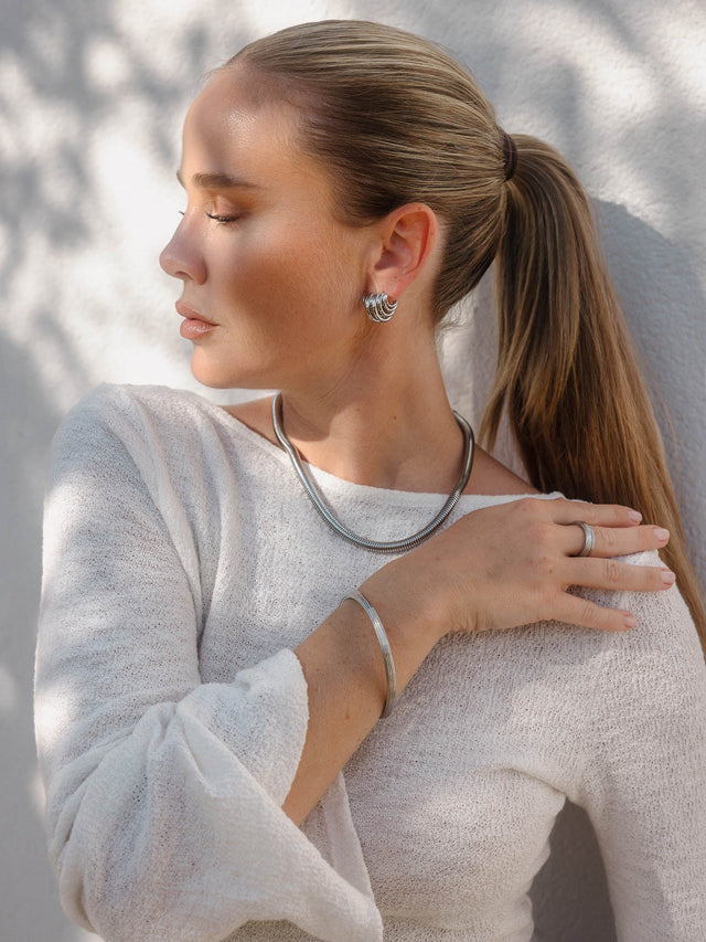 Silberne Schmuckstücke von PURELEI: Creolen, Kette und Armband, elegant und modern.