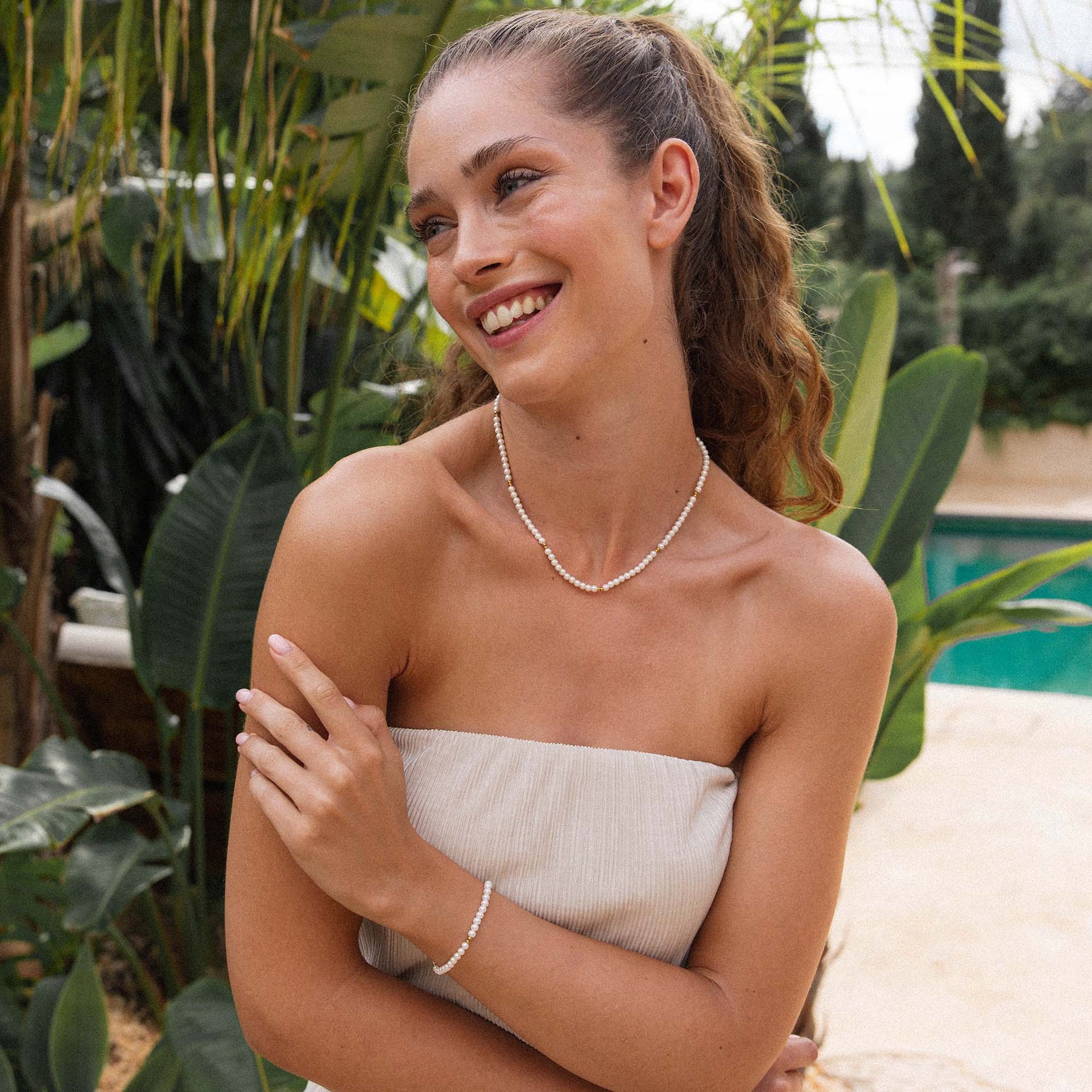 Perlenkette und -armband von PURELEI, elegant und feminin, umgeben von tropischer Natur.