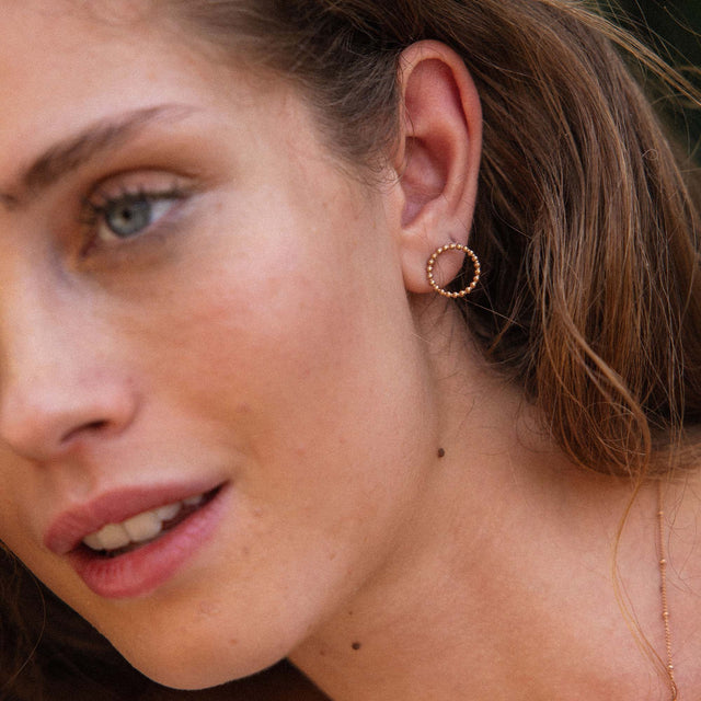 Roségoldene Creolen mit feiner Struktur, getragen von einer Frau, PURELEI.