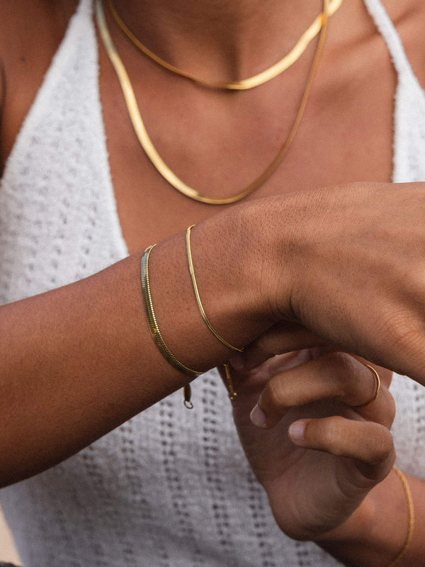 I'lalo Armband in 18K Gold vergoldetem Edelstahl, elegant geschwungen am Handgelenk mit warmem Aloha-Gefühl.