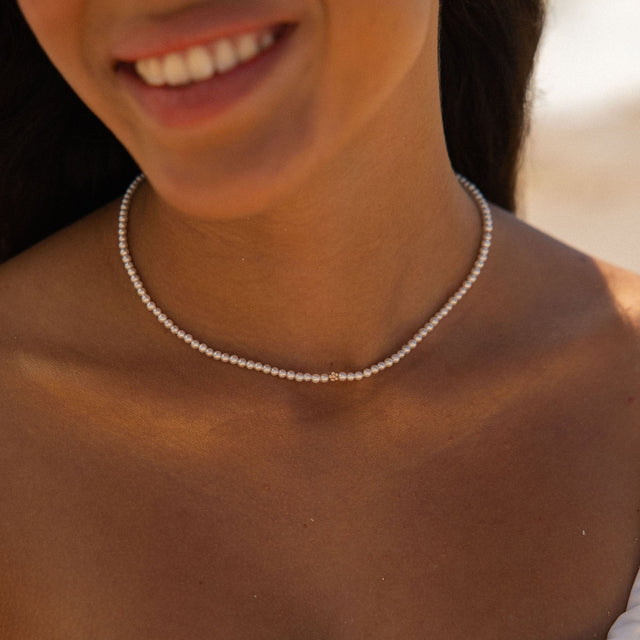 Perlenkette in sanften Tönen, getragen am Hals, inspiriert von PURELEI.