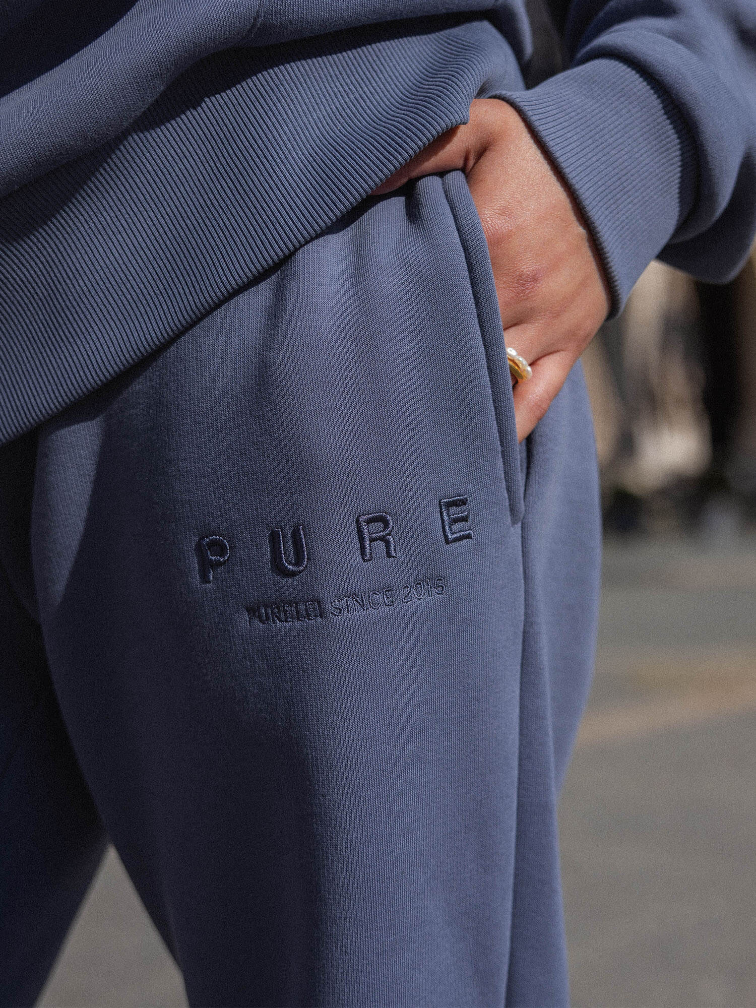 Feeling Pure Sweatpants Dark Blue aus Baumwolle mit geradem Bein und gesticktem PURELEI-Logo in urbaner Atmosphäre