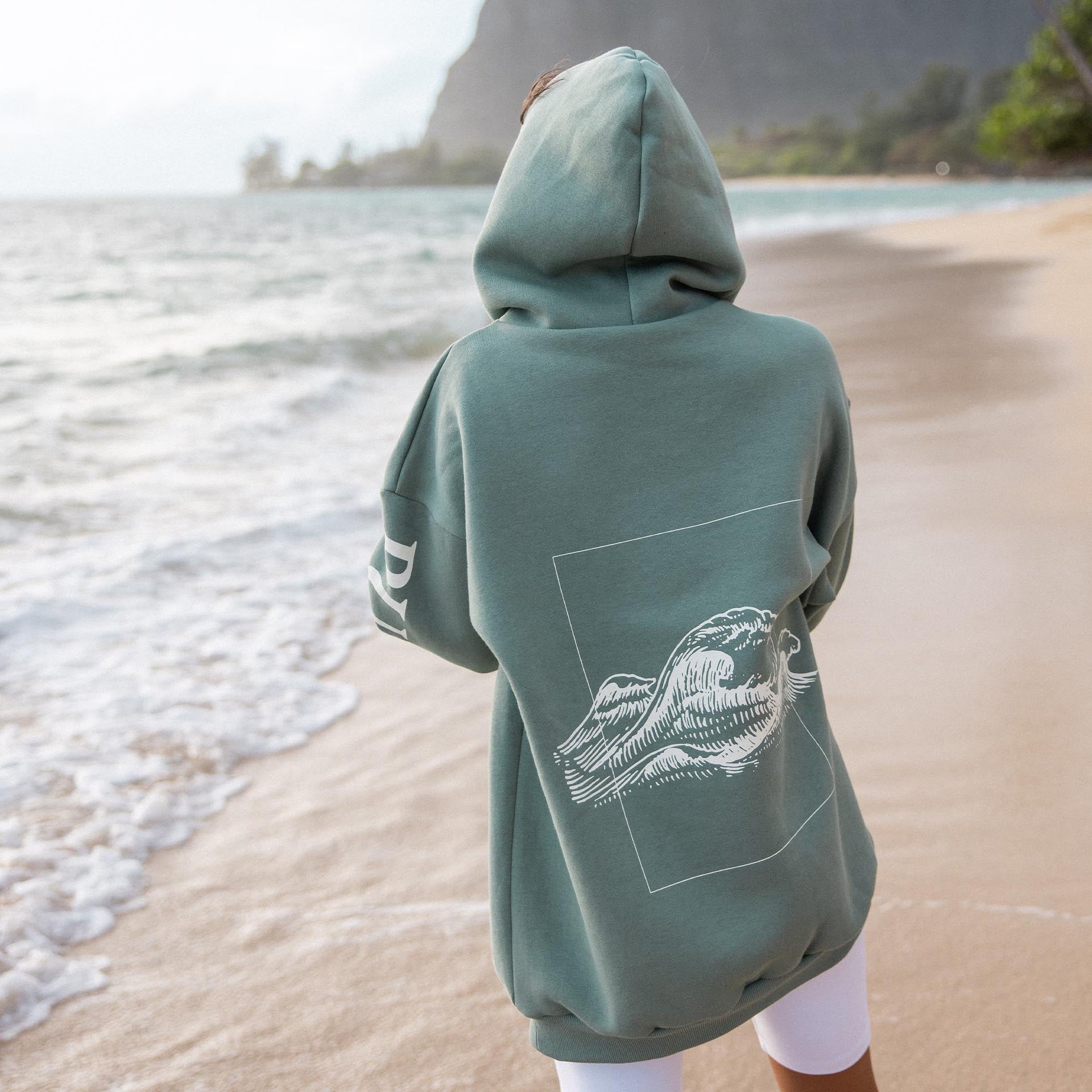 Locker sitzender grüner Wave Hoodie von PURELEI mit Wellenmotiv auf dem Rücken, naturverbunden und entspannt.