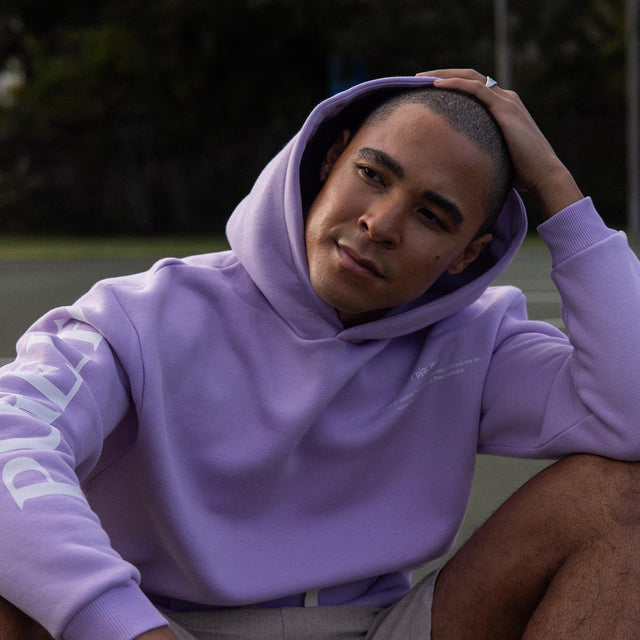 Locker sitzender lila Pure Hoodie aus Baumwollmix mitPRINT auf Brust und PURELEI Schriftzug am Arm, elegant und entspannt.