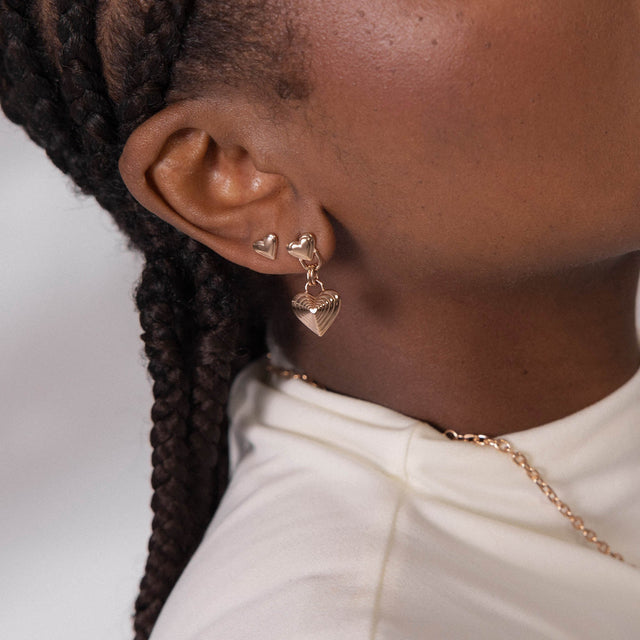 Roségoldene Herz-Ohrringe von PURELEI, elegant und verspielt, getragen in sanfter Lichtstimmung.