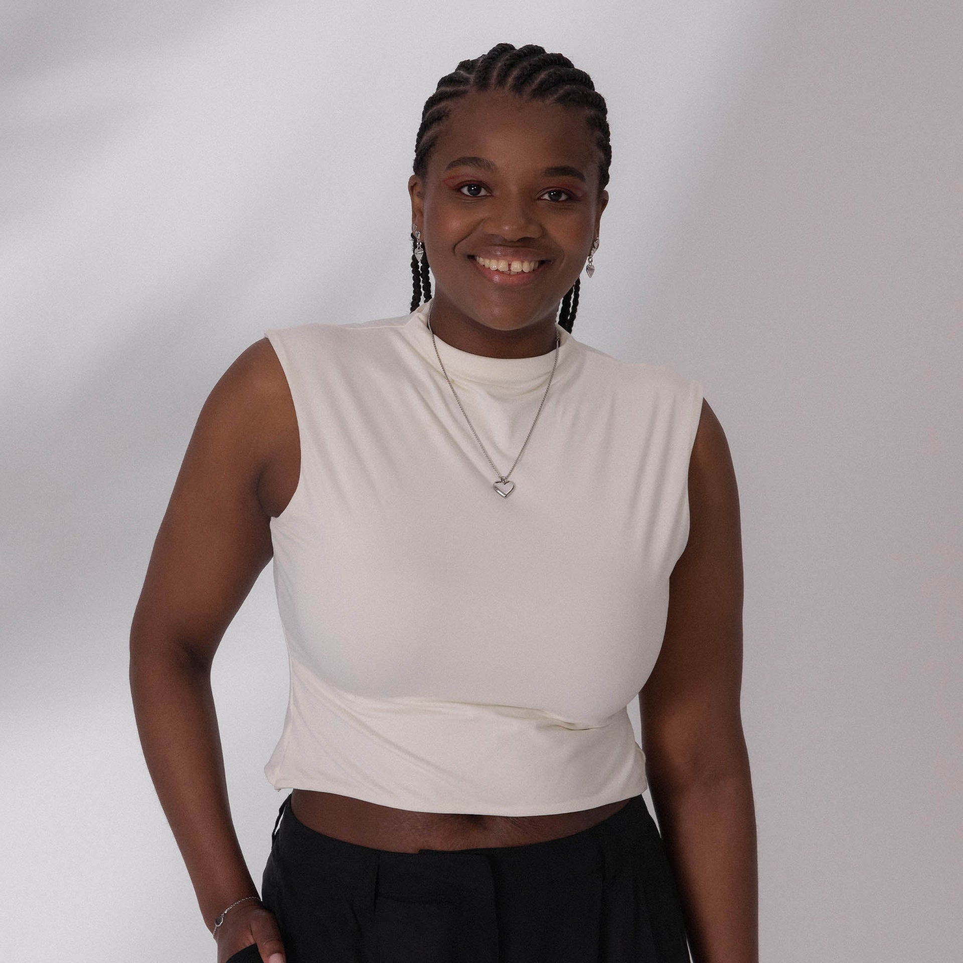 Weißes, schlichtes Oberteil mit PURELEI-Herzanhänger, strahlend und modern.