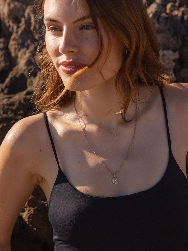 Birthday Blumen Kette von PURELEI mit roségoldenem Blumenanhänger und Perle, getragen am Strand, elegant und feminin