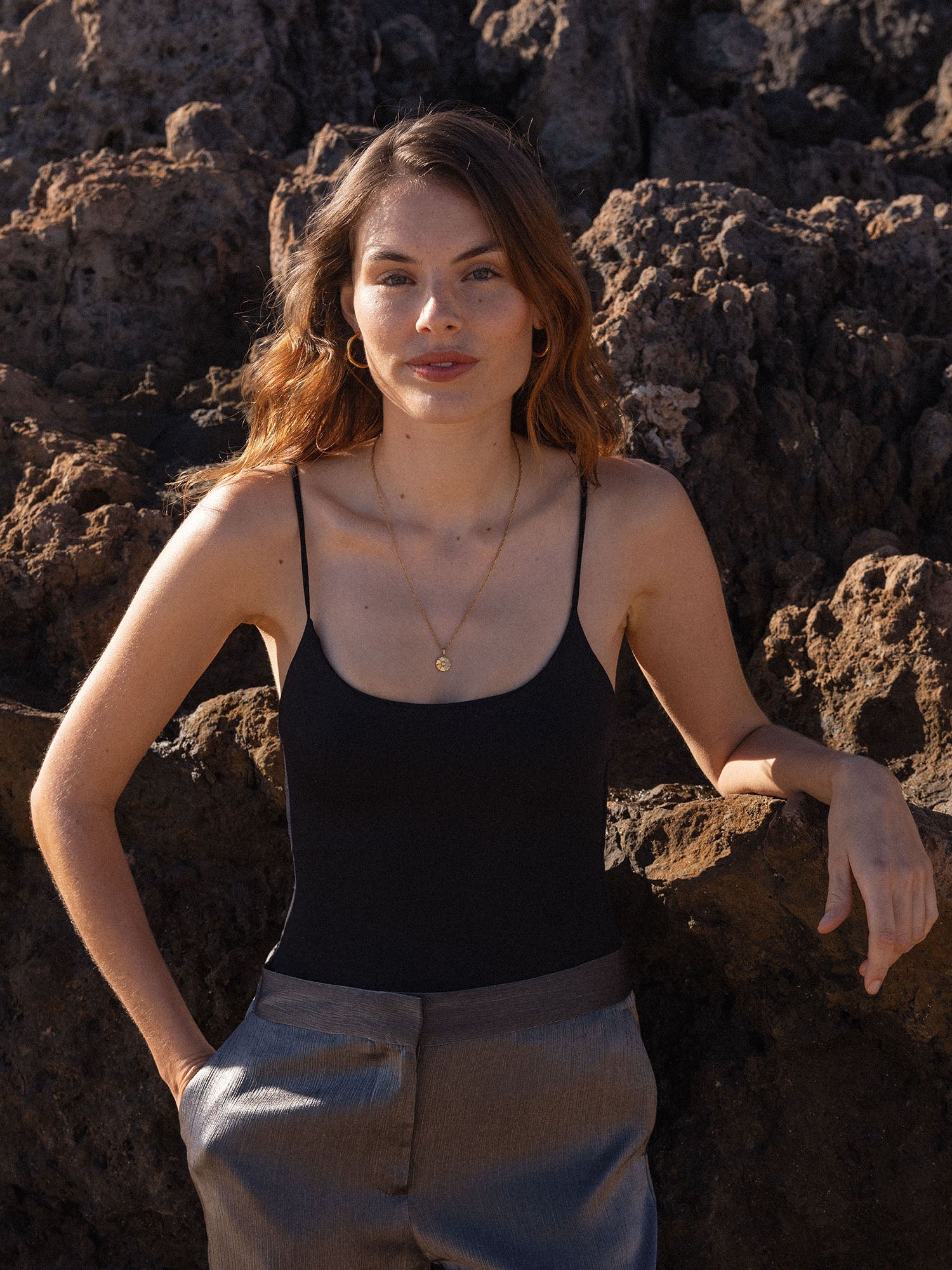 PURELEI Birthday Blumen Kette in Gold mit Muschelperlen-Anhänger, getragen vor vulkanischem Fels, elegant und feminin.