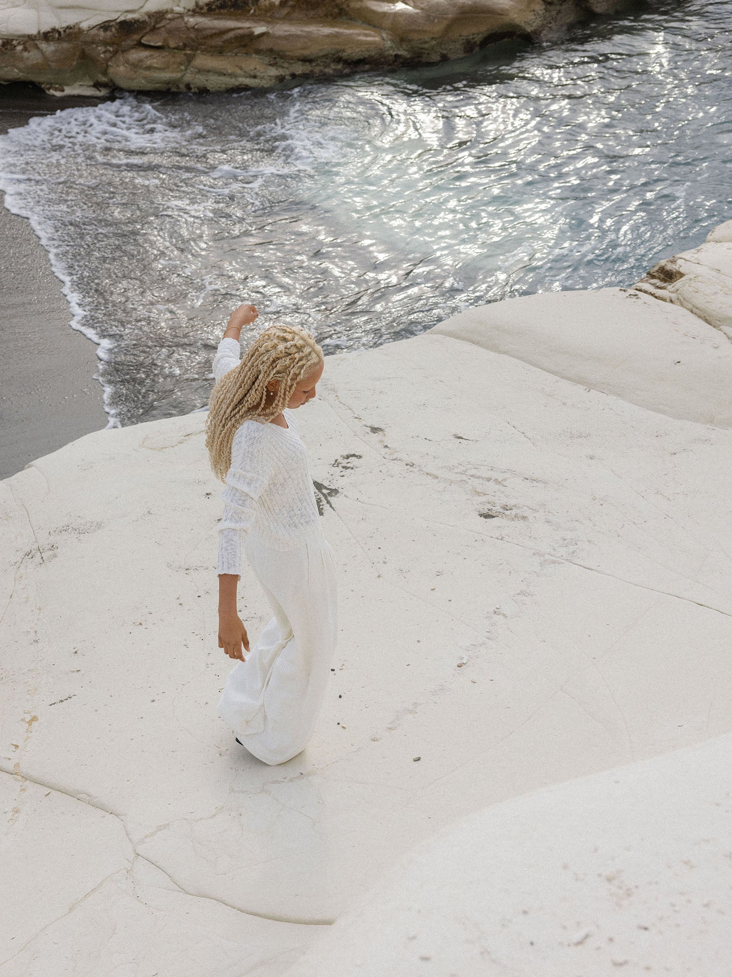 Mahina Club Windrose Ohrringe aus Gold mit schimmernder Süßwasserperle, inspiriert von Insel-Ästhetik bei Sonnenlicht.