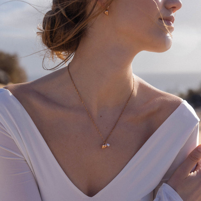 Roségoldene Kette mit Muschel-Anhänger, getragen in tropischer Atmosphäre – PURELEI.