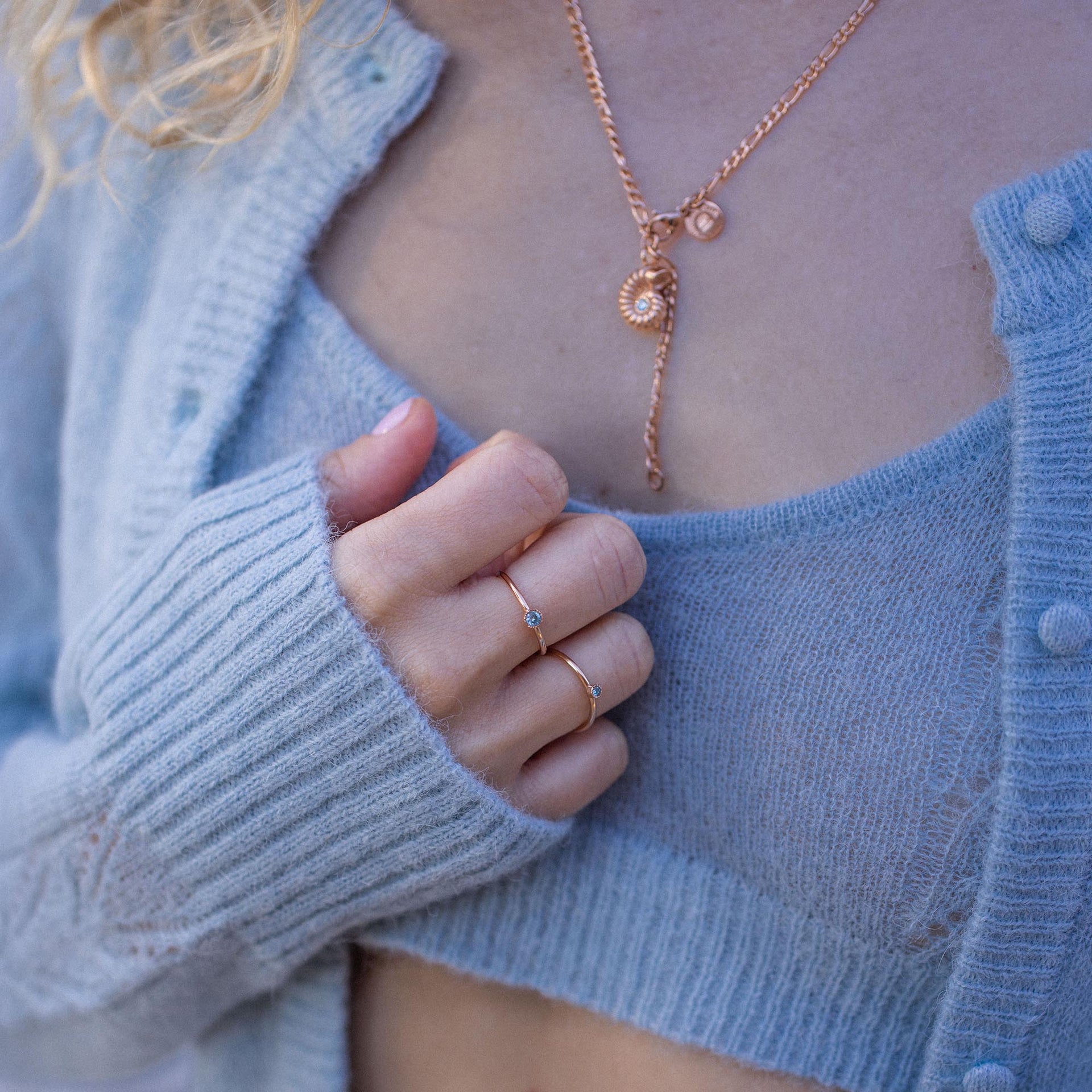 Roségoldene Kette mit Muschel-Anhänger und zartem Ring, PURELEI, in sanften Blautönen.