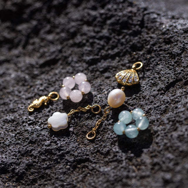 Glänzender Glitter Shell Charm in 18K Gold, mit weißen Zirkonia besetzt, PURELEI, elegante Muschel-Detail.