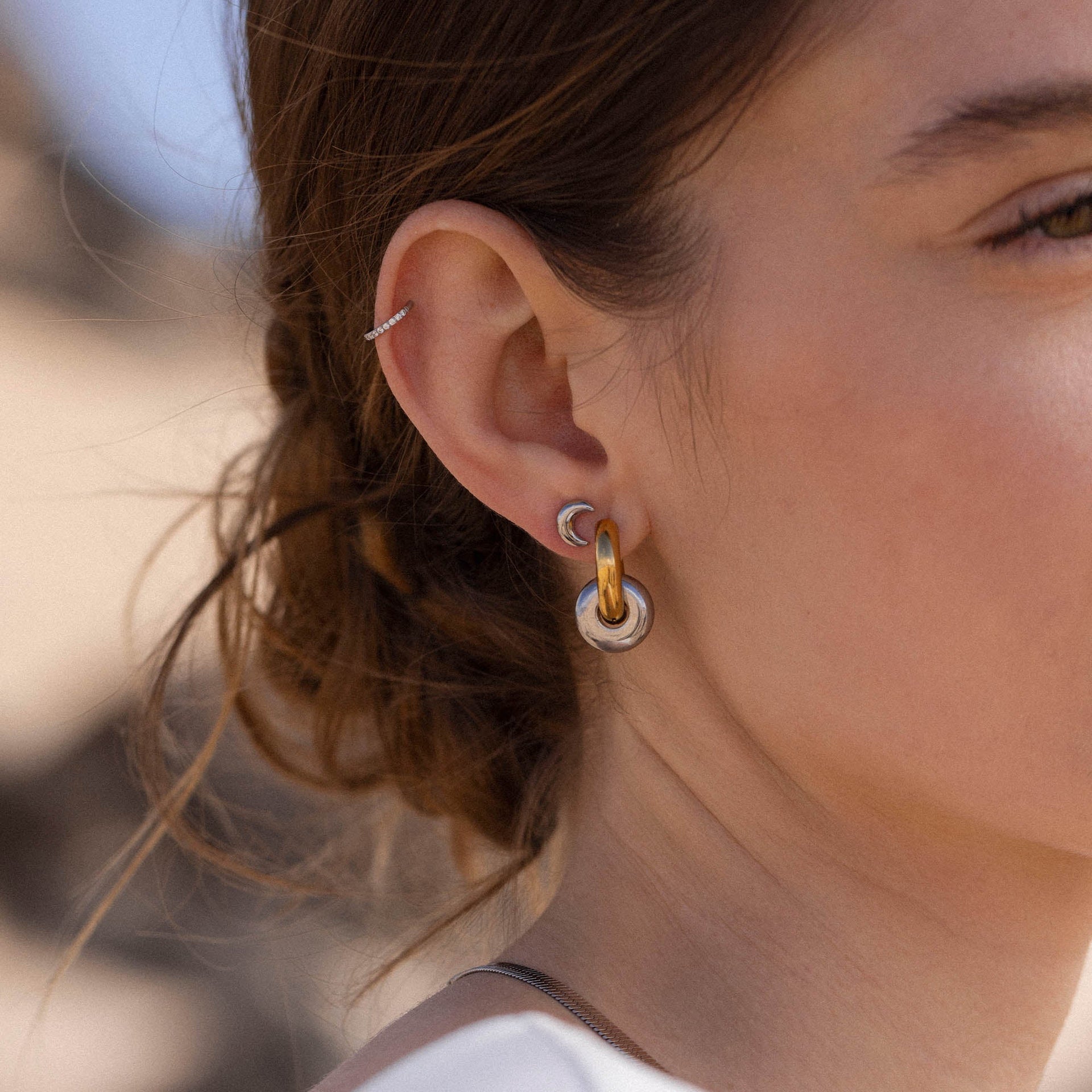 Silberne Creolen mit Roségold-Elementen, getragen in natürlicher Umgebung – PURELEI.