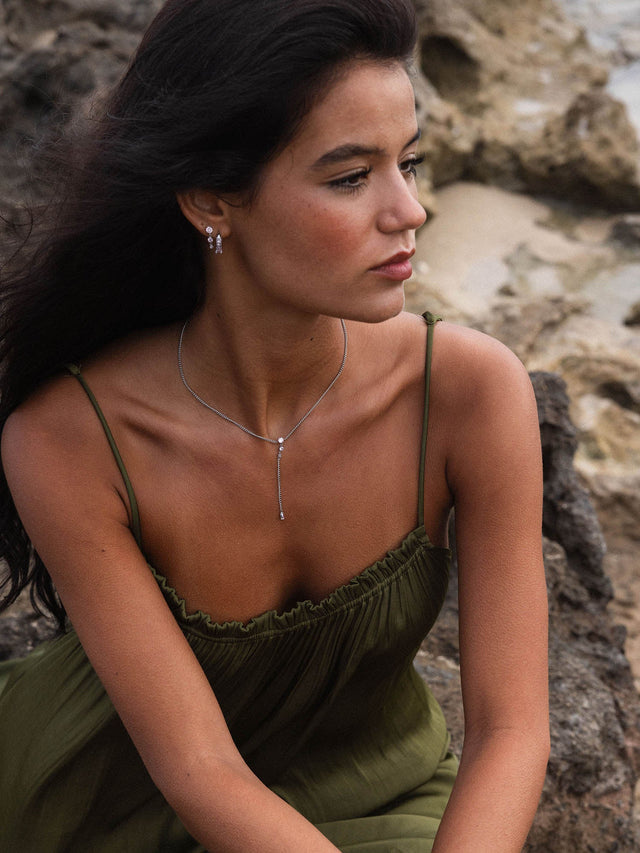 Silberne PURELEI Kette mit zartem Anhänger, getragen in natürlicher Umgebung.