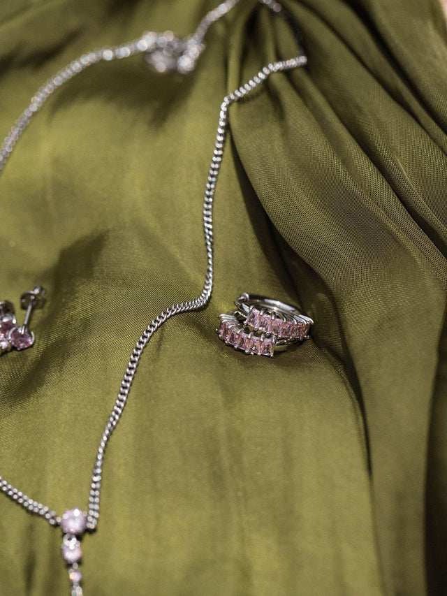 Silberne Kette und Ring auf grünem Stoff, elegant und modern, PURELEI.