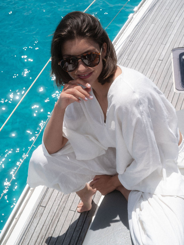 Palm Beach Sonnenbrille von PURELEI mit braunem Schildpatt-Acetat und goldenem Logo, stilvoll am Boot getragen.