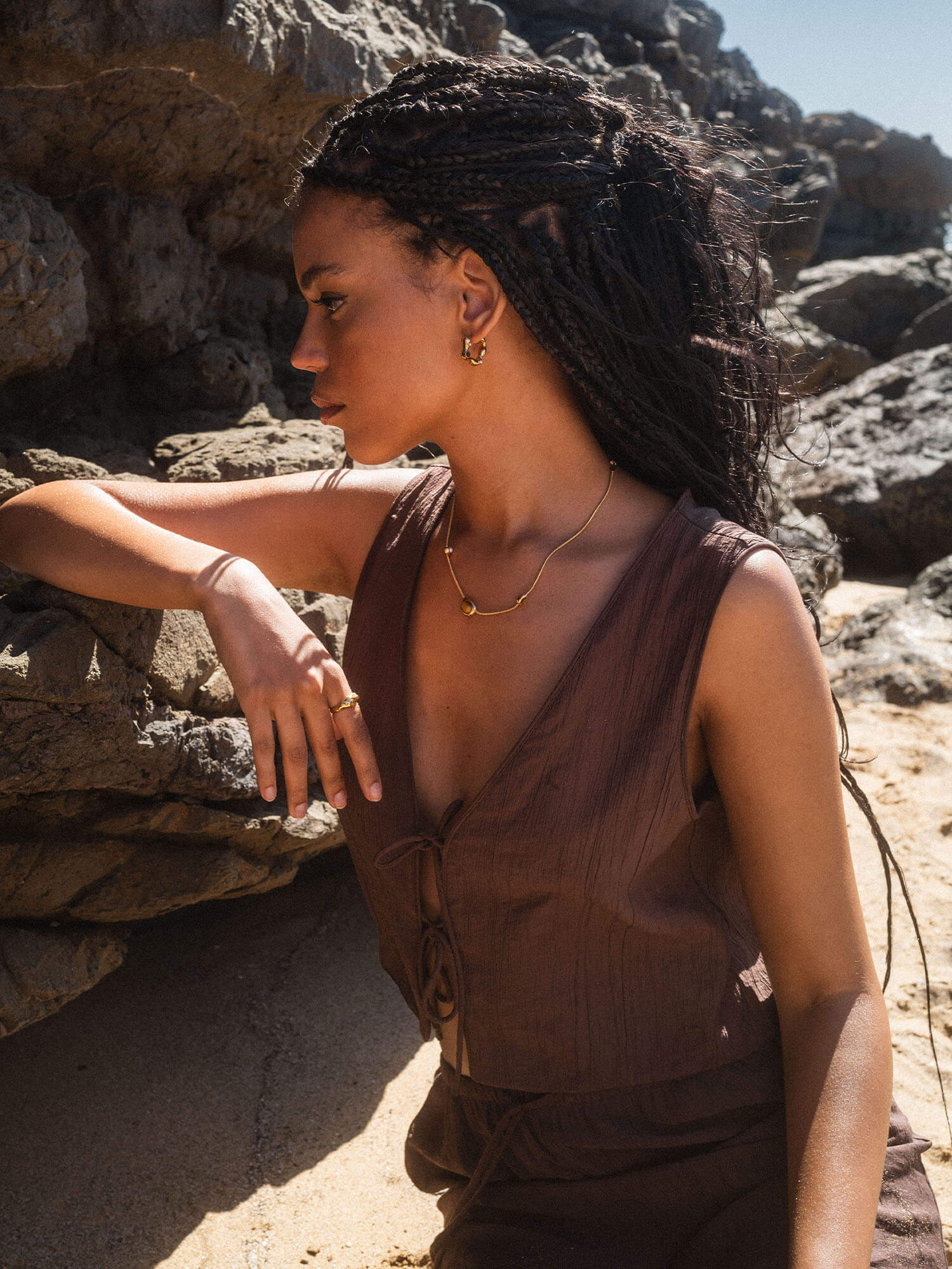 PURELEI Goldkette mit Muschel-Anhänger, getragen in tropischer Umgebung.