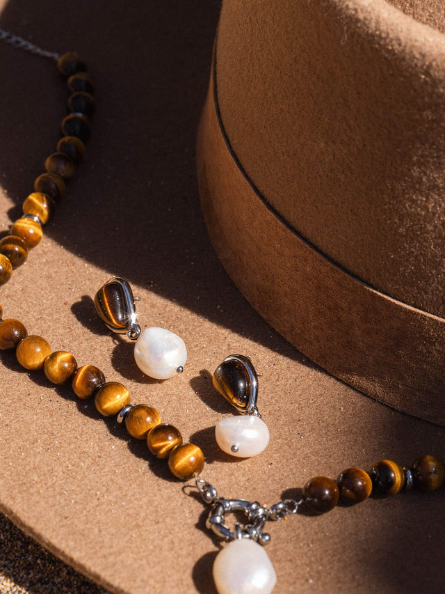 Braune Perlenkette und Ohrringe auf einem Hut, inspiriert von PURELEI.
