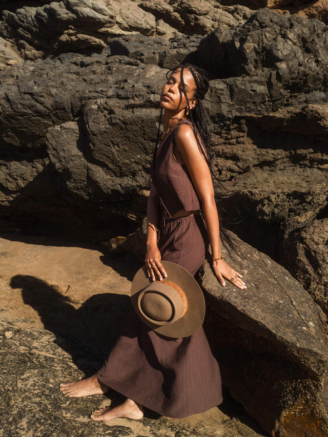 Golden Gaze Ring von PURELEI mit goldbraunem Tigerauge und Süßwasserperle, elegante Naturwärme am Felsenstrand.