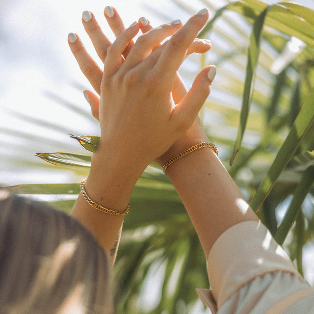 Silbernes Armband mit Kettendesign, getragen unter tropischen Palmen – PURELEI.
