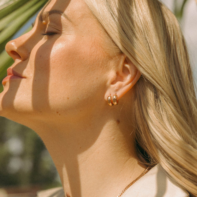 Roségoldene Creolen von PURELEI, elegant und strahlend im Sonnenlicht.