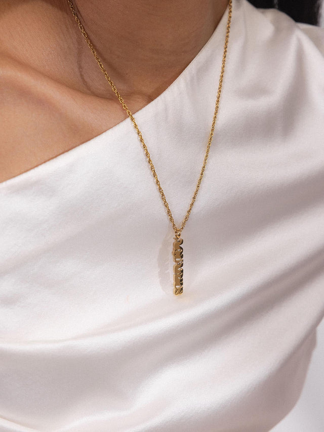 Aquarius Letter Charm aus 18K vergoldetem Edelstahl an zarter Kette, elegant und feminin von PURELEI getragen.