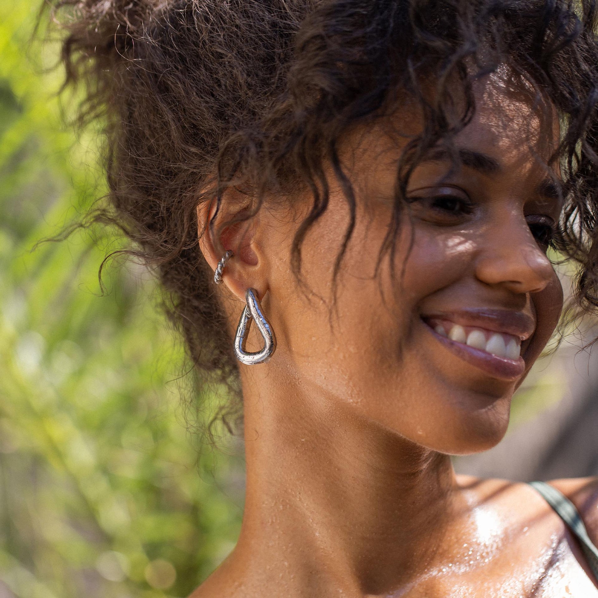 Silberne Tropfen-Ohrringe von PURELEI, elegant und modern, umgeben von natürlichem Licht.