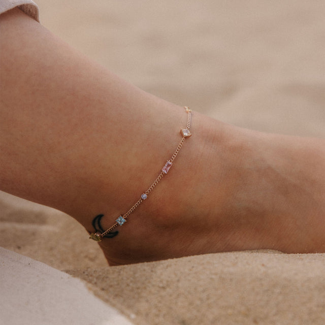 Silbernes Fußarmband mit funkelnden Details, getragen im Sand – PURELEI.