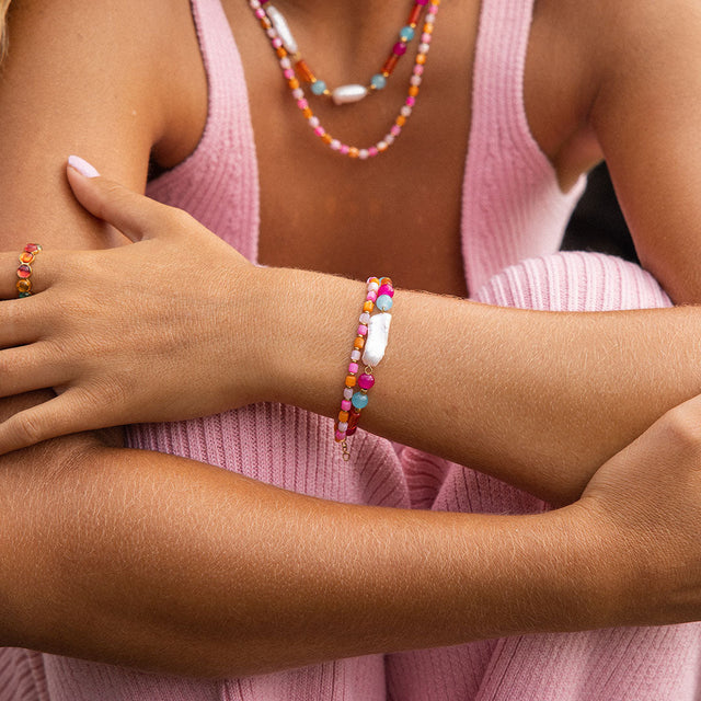 Zartes Armband aus rosa Perlen mit Muschel-Detail, getragen von PURELEI.