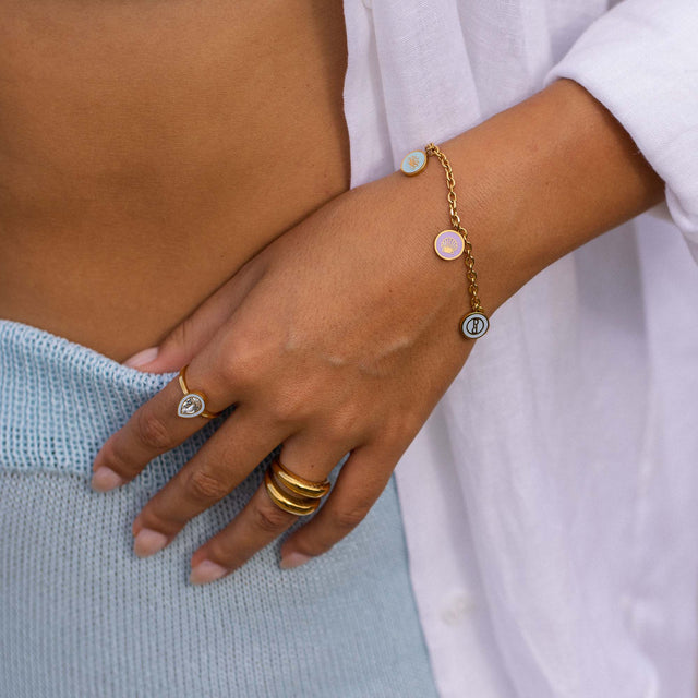 Roségoldenes Armband mit Muschel-Anhängern, getragen mit Ringen von PURELEI.