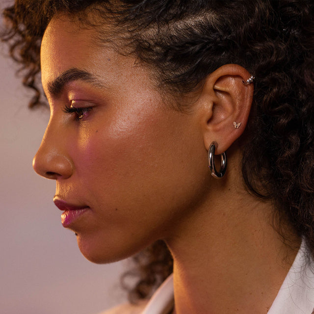 Schwarze Creolen und zarte Schmetterling-Ohrringe von PURELEI, elegant und feminin.