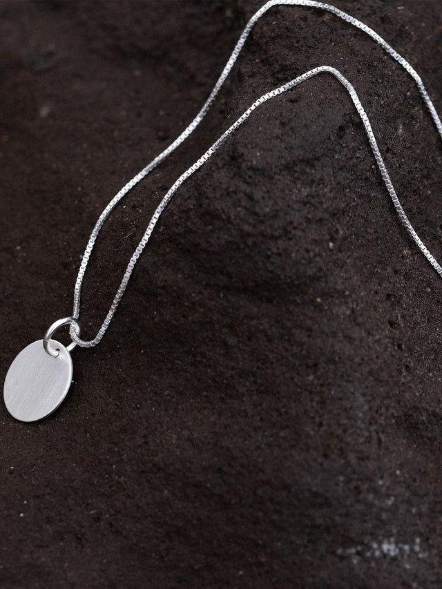 PURELEI Perfection Kette aus recyceltem Silber mit gravierbarem Charm auf dunklem Lavastein, zeitlos elegant.