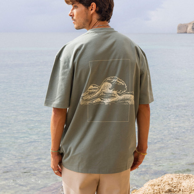 Graues T-Shirt mit Wellenmotiv von PURELEI, lässig am Strand getragen.