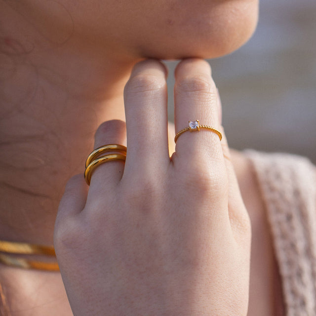 Feiner PURELEI Precious Fine Ring aus 18K Gold Edelstahl mit gedrehtem Band und weißem Zirkonia, elegant getragen.