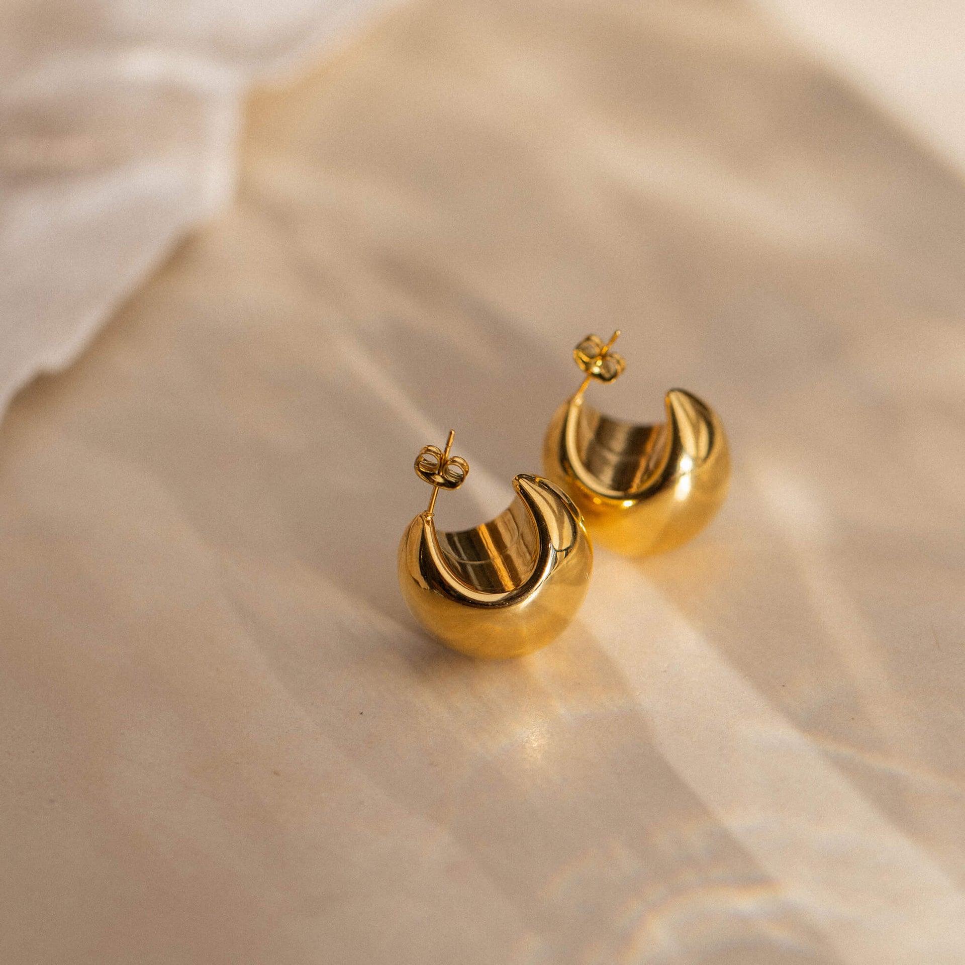 Goldene Creolen von PURELEI mit glänzender Oberfläche, elegant und feminin.