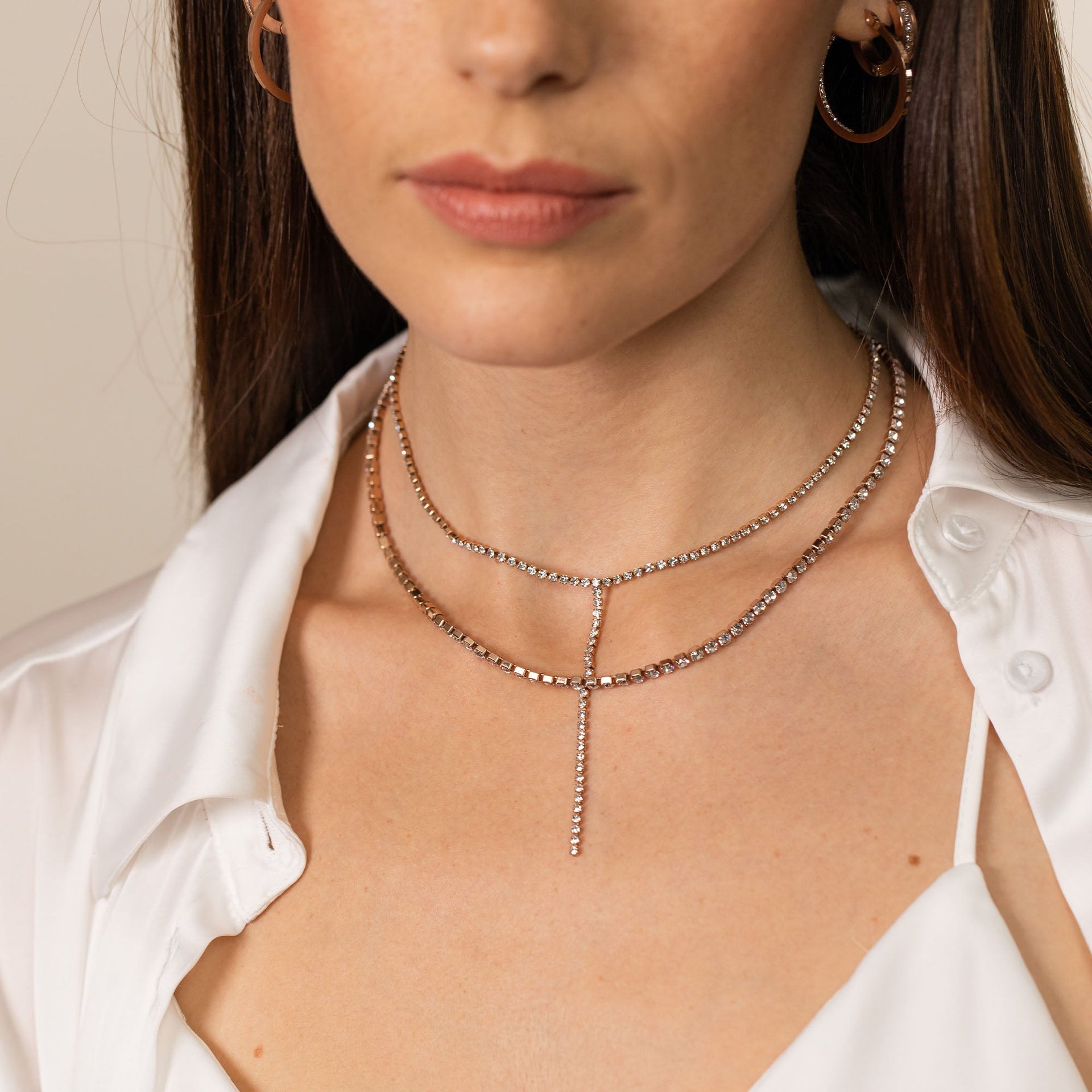 Zweireihige Roségoldkette mit funkelnden Details, getragen mit eleganter Bluse von PURELEI.