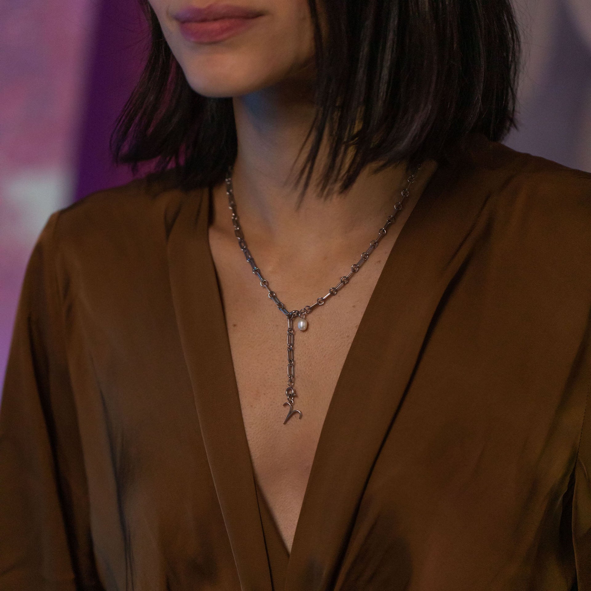 PURELEI Widder Zodiac Charm aus silbernem Edelstahl, elegant am Dekolleté getragen in warmem Abendlicht