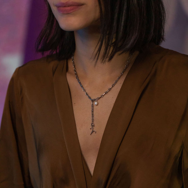 PURELEI Widder Zodiac Charm aus silbernem Edelstahl, elegant am Dekolleté getragen in warmem Abendlicht